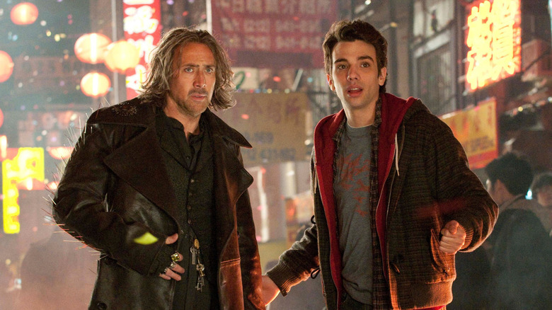Nicolas Cage as Balthazar Blake standing next to Jay Baruchel as Dave Stutler on the street in The Sorcerer's Apprentice