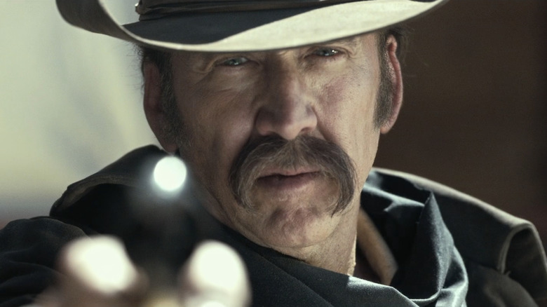 Nicolas Cage's Colton Briggs aims his pistol in closeup in The Old Way
