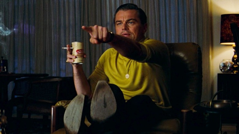 leonardo dicaprio pointing and holding a beer can and cigarette