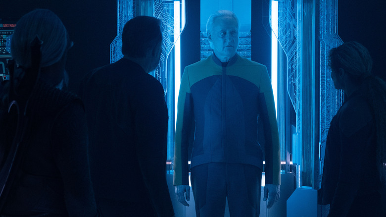 Michelle Herd in the role of Ravi Music, Michael Dorn in the role of Warf, and Jonathan Frex as Will Rikir staring at Brent Spinner while the data was impossible in blue light in Star Treke: Picard
