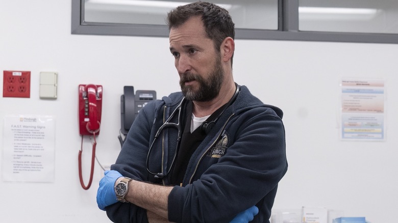 Noah Wyle as Dr. Robby on The Pitt, crossing his arms and looking concerned