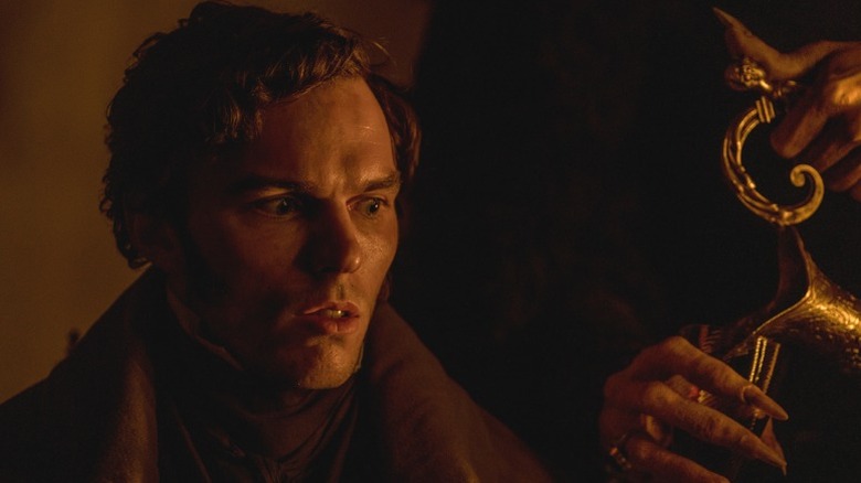 Um atordoado Thomas Hutter aceita uma bebida do Conde Orlok em Nosferatu (2024)