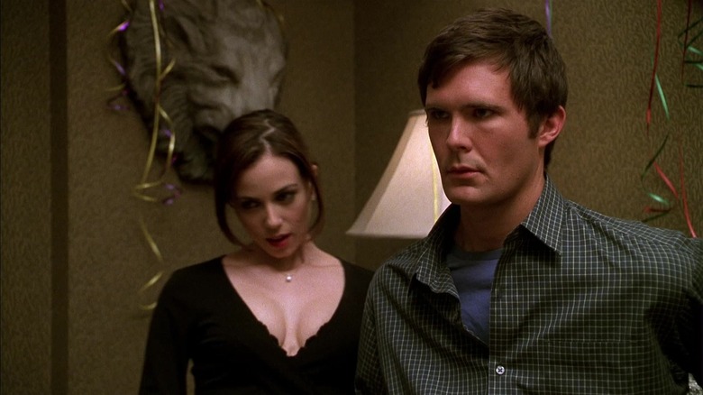 Osgood Perkins as an uninterested guy at a party in Not Another Teen Movie, Mia Kirshner behind him