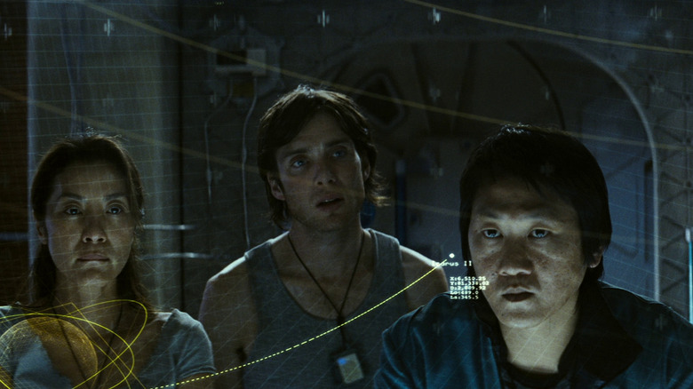 Michelle Yeoh as Corazon, Cillian Murphy as Robert, and Benedict Wong as Trey looking at a chart in Sunshine