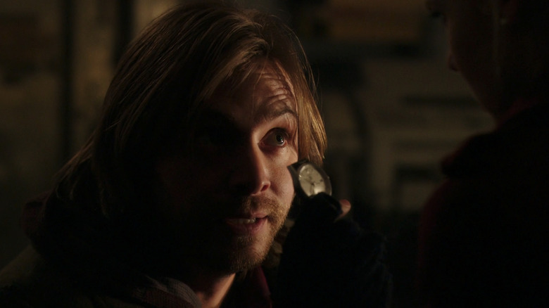 Aaron Stanford's James Cole holds up a watch in 12 Monkeys