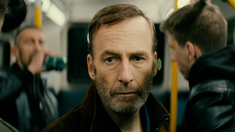 Hutch Mansell surrounded by drunk guys on a bus in Nobody