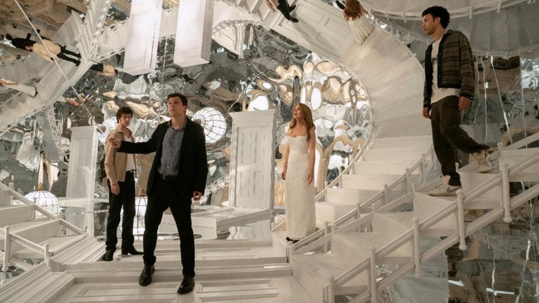 Jesse Eisenberg as J. Daniel Atlas, Isla Fisher as Henley Reeves, and Dominic Sessa and Justice Smith as unknown characters standing in a room full of mirrors in Now You See Me: Now You Don't