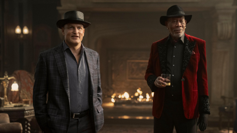Woody Harrleson as Merritt McKinney standing by Morgan Freeman as Thaddeus Bradley as he drinks whiskey in Now You See Me: Now You Don't