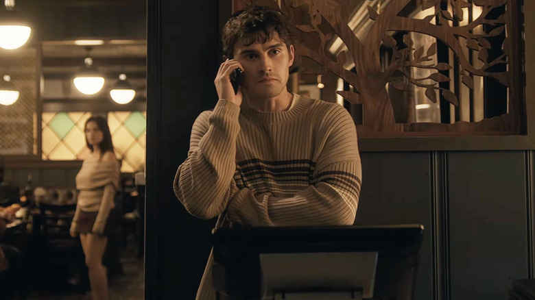 Michael Johnston as Bear talking on the phone as Inde Navarrette as Nikki lurks in the background in Obsession