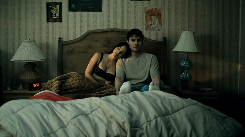 Nikki leaning on Bear in bed in Obsession