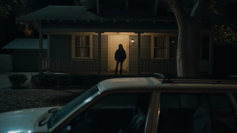 Nikki standing on a porch in Obsession