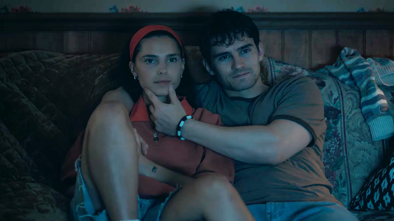 Inde Navarrette as Nikki sitting on the couch next to Michael Johnston as Bear holding her chin in Obsession