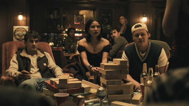 Bear, Sarah, and Ian sit and look at Nikki in horror during the party scene in Obsession