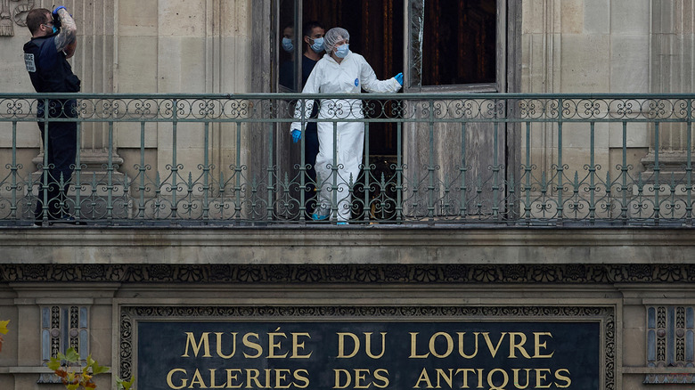 A forensics crew inspects the balcony of the Louvre Apollo gallery