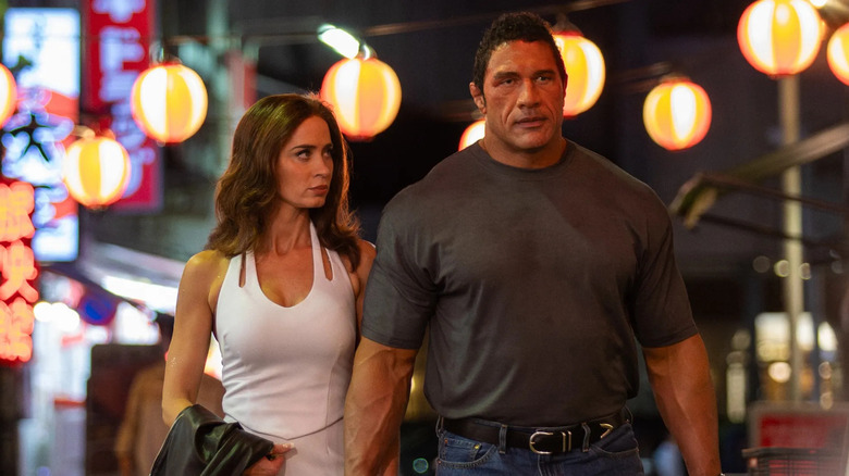 Dwayne Johnson as Mark Kerr leaning up against the wall with sweat all over his face in The Smashing Machine