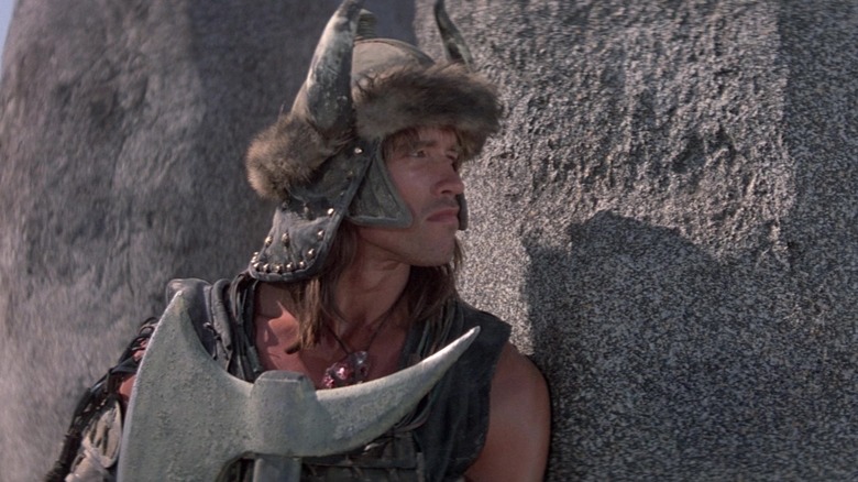 Conan houdt een bijl vast en draagt een helm in Conan the Barbarian