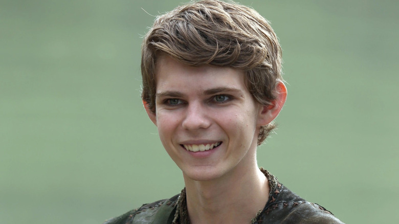 Robbie Kay as Peter Pan, smiling in a field of grass on Once Upon A Time