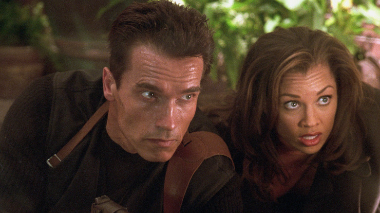 John (Arnold Schwarzenegger) and Lee (Vanessa Williams) lying on the ground in 