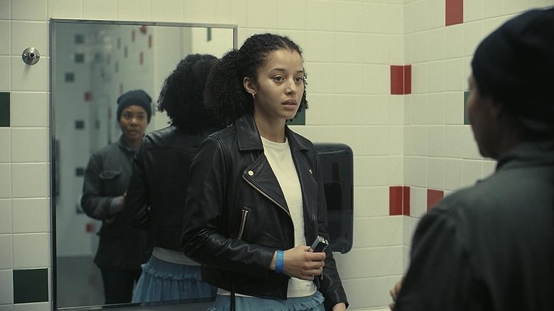 Chase Infiniti as Willa being approached in the bathroom by Regina Hall as Deandra in One Battle After Another