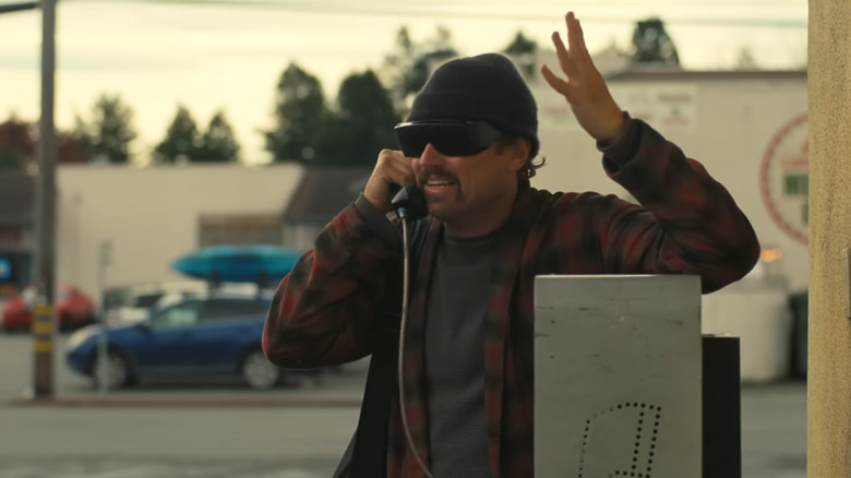 Bob Ferguson looking confused at a pay phone in One Battle After Another