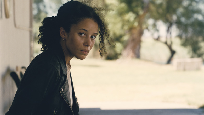 Chase Infiniti as Willa Ferguson looking disheveled while tied to a chair in One Battle After Another