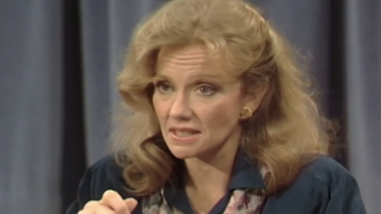 Hayley Mills' Carrie Bliss is seen in closeup as she sits in front of a curtain in Saved by the Bell