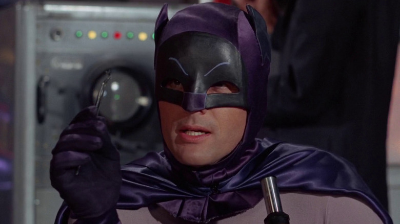 Batman houdt een pincet vast voor een microscoop in Batman