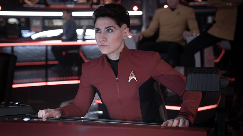 Celia Rose Gooding as Uhura, Mynor Luken as Beto, and Melissa Navia as Erica Ortegas standing by a bar and holding drinks in Strange New Worlds