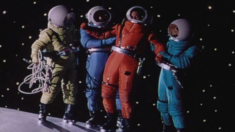 Quatre astronautes à l'extérieur d'un vaisseau rocheux dans Destination Moon