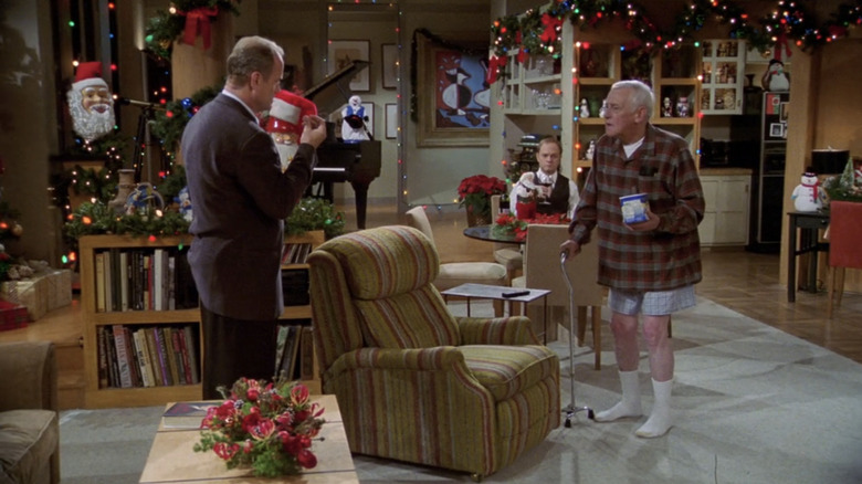 Martin stands in Frasier's living room without his pants on as Frasier questions him and Niles looks on from the table