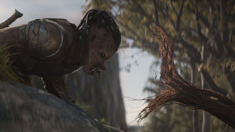 Dimitrius Schuster-Koloamatangi as Dek facing off with a tree tentacle in Predator: Badlands