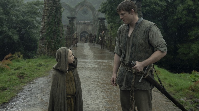 Dexter Sol Ansell as Egg standing next to Peter Claffey as Dunk on a rainy pathway in A Knight of the Seven Kingdoms