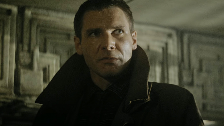 Rick Dikard from Harrison Ford stands in his apartment in Blade Runner