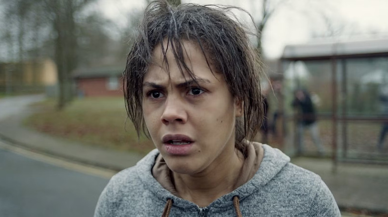 Victoria with messy hair and a gray hoodie looking scared in Black Mirror