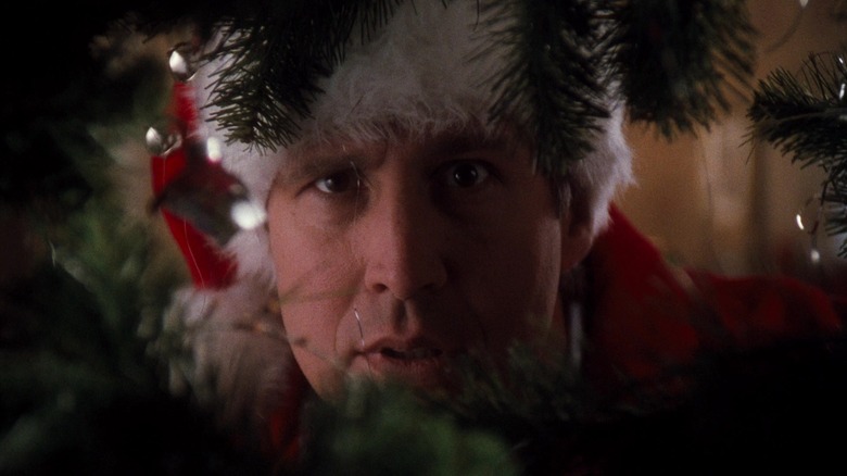 Clark looking into a gap in a Christmas tree in National Lampoon's Christmas Vacation
