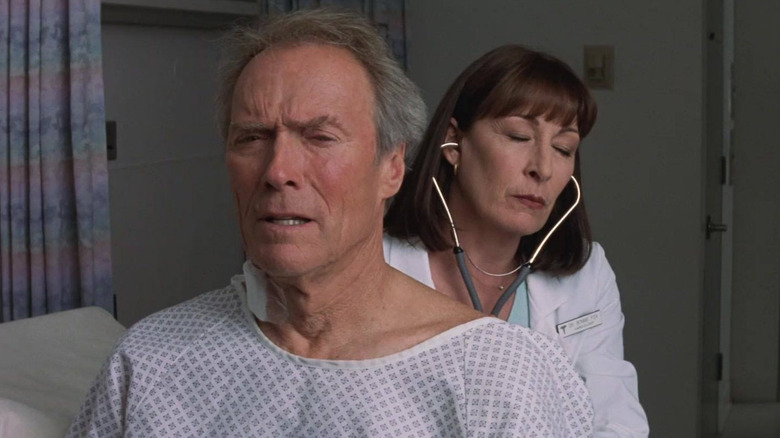 Terrell McCaleb (Clint Eastwood) being assessed in a hospital by Dr. Bonnie Fox (Anjelica Huston) in Blood Work