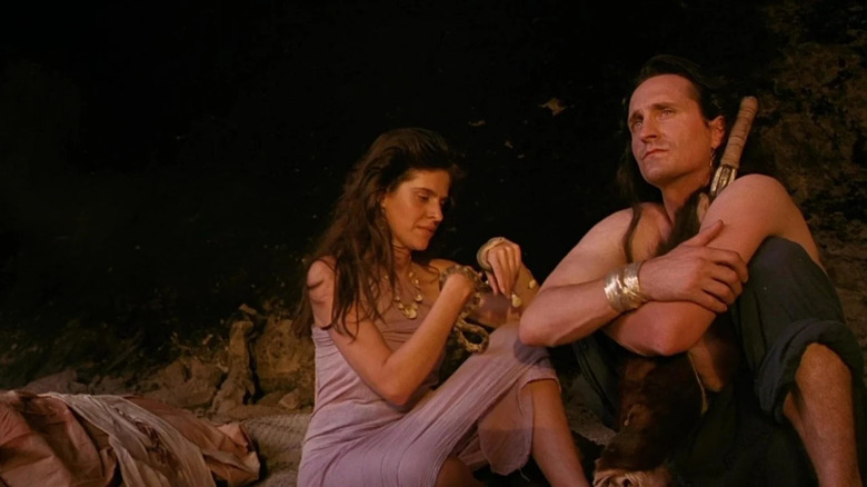 A woman and a man in a cave, both wearing desert clothes in Nightfall