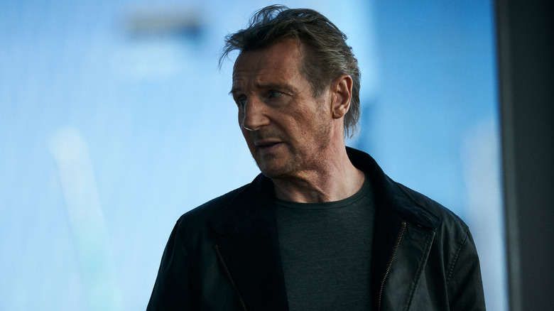 Liam Neeson as Travis Block in a leather jacket looking concerned in the movie Blacklight