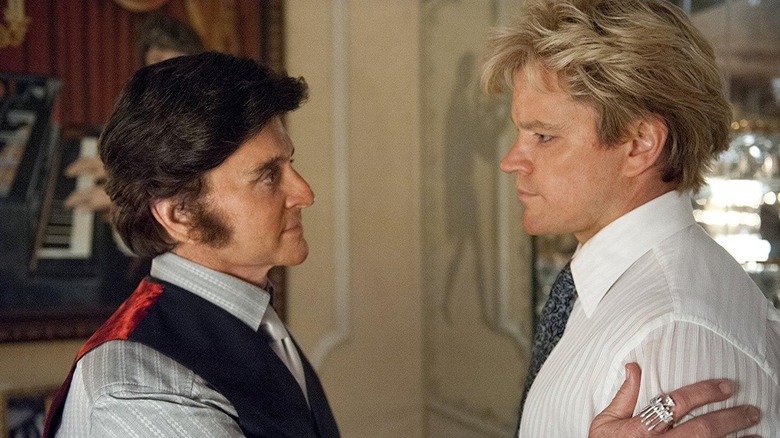 Michael Douglas as Liberace putting his hand on the shoulder of Matt Damon as Scott in Behind the Candelabra