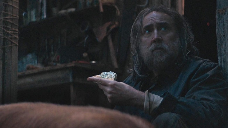 Nicolas Cage as Robin Feld sits outside with his pig in Pig
