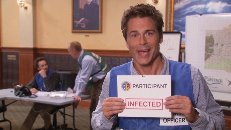 Chris looking surprisingly happy despite holding a sign that says infected in Parks and Recreation