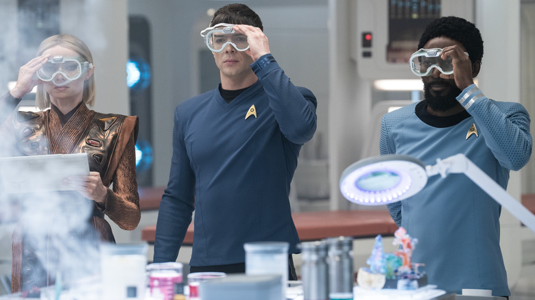 Jess Bush as Nurse Chapel, Ethan Peck as Spock, and Babs Olusanmokun as Dr. M'Benga wearing safety goggles in Star Trek: Strange New Worlds