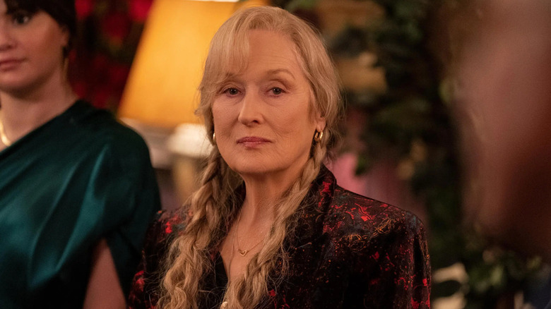 Loretta with braids in her hair looking suspiciously at somebody on Only Murders in the Building