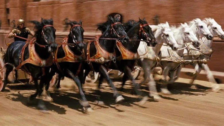 A chariot racer holding onto multiple horses' reins in Ben-Hur