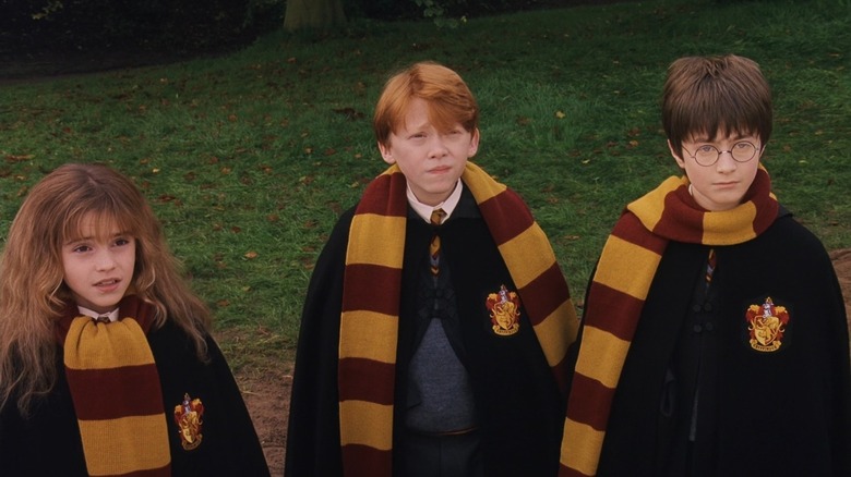 Hermione, Ron, and Harry wearing Gryffindor scarves in the 