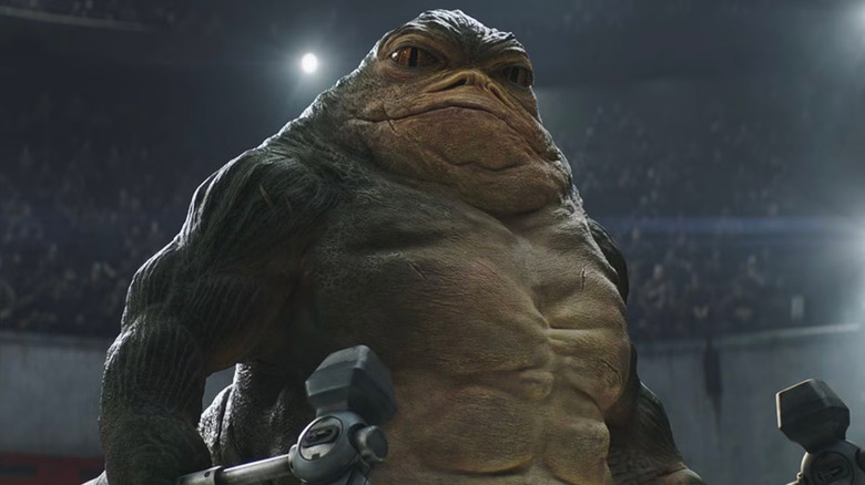 Rotta the Hutt holding axes in a battle arena in The Mandalorian and Grogu