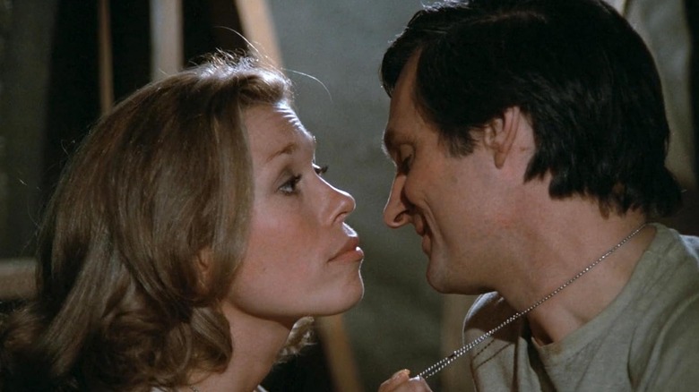 Lynnette Mettey as Nancy and Alan Alda as Hawkeye getting cozy in M*A*S*H