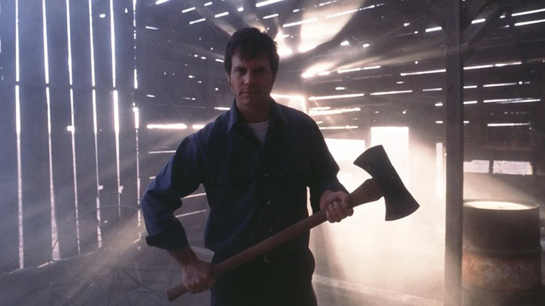 Dad holds an axe in a barn filled with creepy light in Frailty