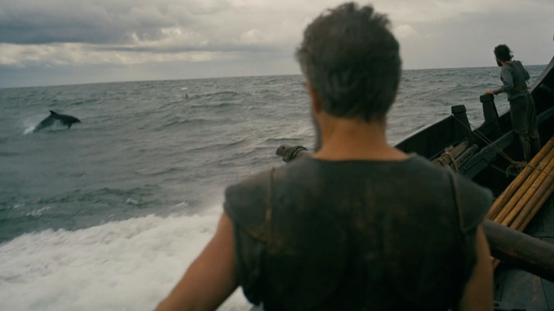 Matt Damon as Odysseus watching dolphins in the water in The Odyssey