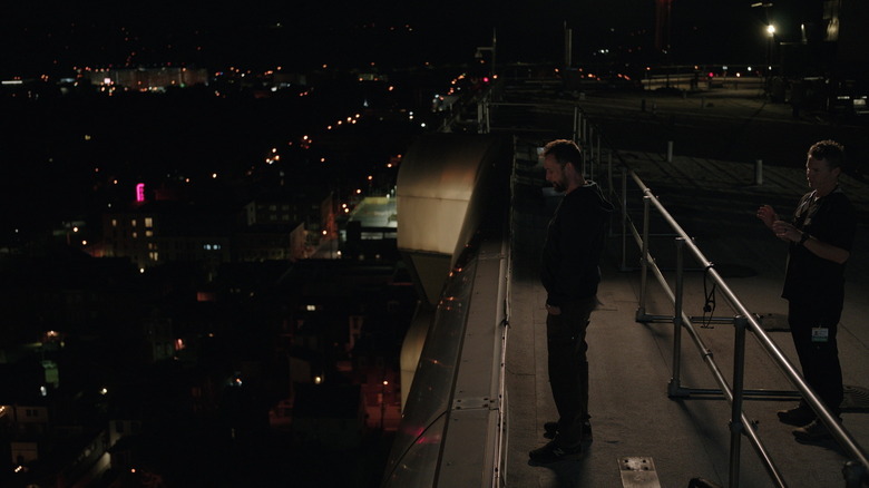 Robby at the edge of the roof with Abbot behind him on The Pitt